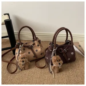 Gedetailleerd overzicht van trendy stippen emmertassen met schattige pluche hondenhangers.