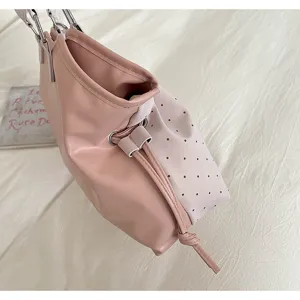 Pink leather handbag detail showcasing drawstring closure and chic perforated side panel.