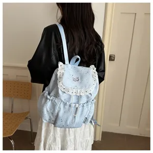 Gros plan détaillé du sac à dos bleu clair à motif d'étoiles avec dentelle et cordon.