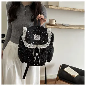 Vue détaillée du sac à dos noir imprimé d'étoiles avec bordure en dentelle blanche et cordon.