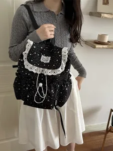 Sac à dos en toile imprimé étoiles noires avec bordure en dentelle blanche et cordon de serrage.