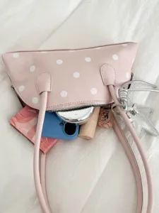 Stylish pink polka dot patent leather shoulder bag, chic underarm bag for women daily use.