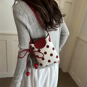 Vista ravvicinata dettagliata della borsa a tracolla a pois da donna con patta e coulisse.