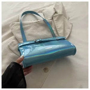 Blue holographic shoulder bag detail, shiny patent leather underarm handbag style.