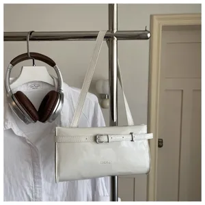 White patent leather shoulder bag with chic buckle detail, stylish minimalist underarm handbag.