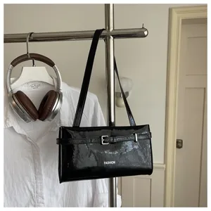 Black patent leather shoulder bag underarm bag chic minimalist casual handbag detail shot.