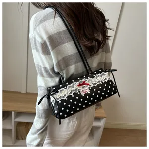 Chic black and white polka dot shoulder bag with delicate white lace and red bow detail.