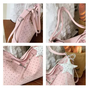 Pink polka dot tote shoulder bag detail view showing straps, metal grommets and star charm.