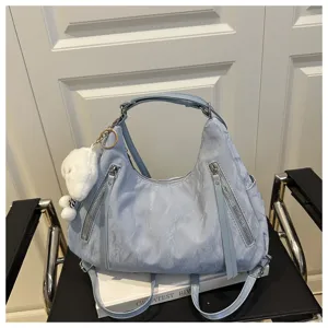 Light blue casual hobo shoulder bag with front dual zippers and cute plush pendant charm detail.