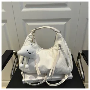 Detail view of the stylish white hobo shoulder bag with cute cloud pendant and zipper pockets.