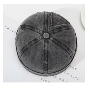 Nahaufnahme der gewaschenen dunklen Denim-Docker-Mütze mit Patch und markanten Nähten.
