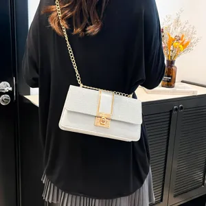 Close-up view of women's glitter flap crossbody bag with golden chain strap and lock.