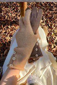 Primer plano de guantes táctiles de punto de invierno con botones en el exterior en otoño.
