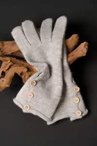 Detalle de guantes de invierno de punto gris con botones de madera, cálidos y elegantes.