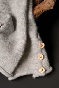 Detalle guante invierno punto gris con botones madera, textura tejido calido