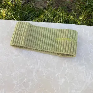 Gruenes Strickstirnband mit gestickten Buchstaben, perfektes modisches Damenhaaraccessoire.