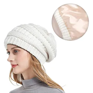 Close up view of the warm slouchy knit beanie showing smooth satin lining and soft texture.