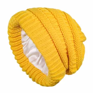 Detailed view of yellow knit slouchy beanie with smooth satin lining for hair protection.