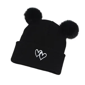 Cute baby black knitted beanie hat with double pom poms and white heart embroidery main view