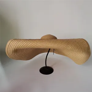 Detailed view of the oversized straw hat showing wide brim texture and woven material.