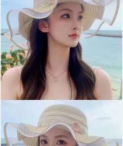 Détails exquis de ruban floral sur chapeau de paille à large bord, idéal pour la plage.