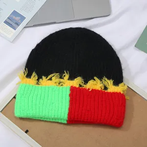 Nahaufnahme der bunten Strickmütze mit auffälligem Farbdesign und dekorativen Fransen.