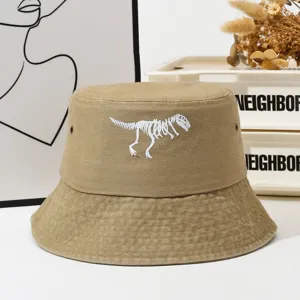 Washed distressed khaki bucket hat featuring a cool white dinosaur skeleton embroidery design.