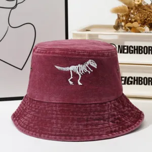 Vintage washed burgundy bucket hat featuring a cool white dinosaur skeleton embroidery for outdoor wear.