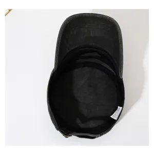 Gedetailleerd uitzicht op vintage gewassen zwarte platte pet, casual katoenen militair hoedje.