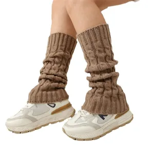 Braune Strick Beinstulpen für Damen im Zopfmuster Design kombiniert mit weißen Sneaker Schuhen.