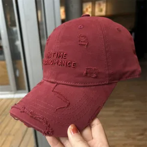Vue de détail d'une casquette de baseball en coton lavé avec broderie et effet usé.