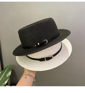 Close up detail of women flat top straw hat with black belt and metal buckle decor
