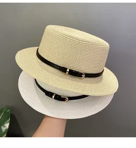 Detail shot of summer straw fedoras, stack of beige and white flat-top hats with black belts.