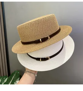 Detailed view of stacked flat-top straw hats with brown leather belts and metal buckles.