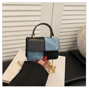 Details of the trendy color-block crossbody bag with chic chain strap and top handle.