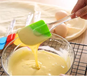 Silicone baking spatula with clear handle for mixing cream and cake batter in kitchen.