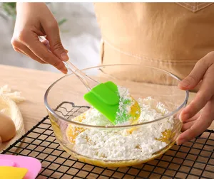 Silicone baking spatula with clear handle and green head for mixing cream, batter, and cake.