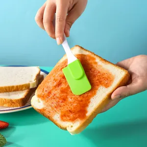 Kleiner Silikonspatel zum Verteilen von Marmelade, Butter und Sahne mit weißem Griff.