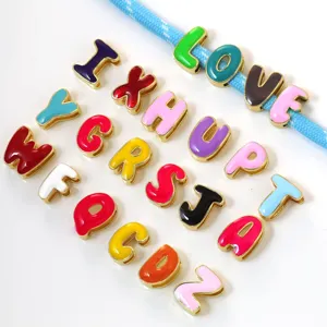 Close-up of colorful enamel letter charms, gold-plated copper alphabet pendants for DIY jewelry.