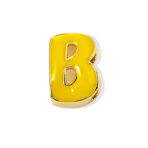Gold plated copper letter B charm with bright yellow enamel, detailed pendant component.