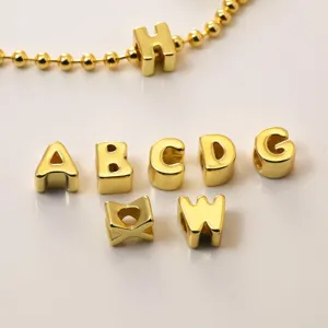 Primer plano detallado de abalorios con letras de metal dorado para joyas y accesorios.