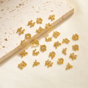 Primo piano dettagliato di ciondoli con lettere dell'alfabeto in zircone oro brillante.