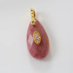 Roze natuurstenen druppelhanger met stralende zirkoon ster en elegant gouden oogdetail.