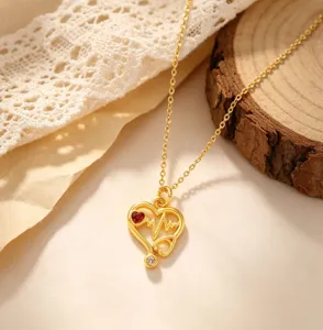 Exquisite gold-plated stethoscope heart pendant necklace featuring red crystal and clear zircon.
