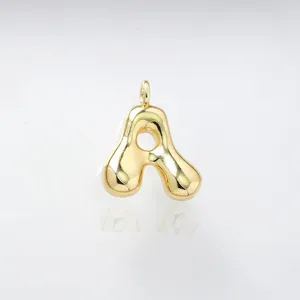 Detail shot of gold puffy letter A pendant, smooth shiny finish, jewelry component.