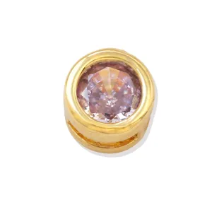 Close-up detail of a round 18k gold plated DIY charm pendant with sparkling pink cubic zirconia.