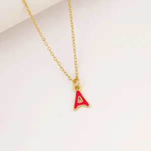 Primo piano dettagliato di una collana con catena dorata e ciondolo con lettera A rossa.