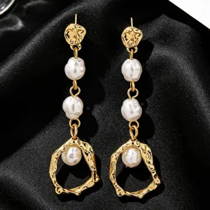 Detailed macro view of vintage gold molten drop earrings featuring elegant white baroque pearls