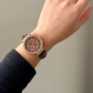 Close-up of Scottie quartz watch featuring rhinestone bezel and brown leather strap