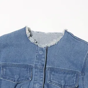 Detailansicht einer blauen Jeansjacke mit ausgefranstem Rundhalsausschnitt und Taschen